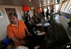 Crew members gather on the bridge of Sabuk Nusantara, Oct. 4, 2018, in Wani village on the outskirt of Palu, Central Sulawesi, Indonesia Indonesia. A week after the magnitude 7.5 quake and tsunami hit central Sulawesi, the crew of the ferry remain on board, waiting for an assessment team to arrive and decide if the ship could be put back to sea.