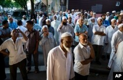 FILE - People gather near a crime scene for a demonstration after the leader of a New York City mosque and an associate were fatally shot in a brazen daylight attack as they left afternoon prayers, Aug. 13, 2016.