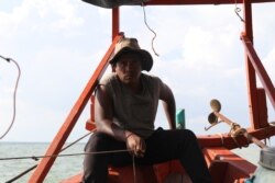 លោក អ៊ុត សុភា អាយុ៣២ឆ្នាំ ប្រជានេសាទម្នាក់ក្នុងខេត្តកែប កំពុងបញ្ជាទូករបស់លោកតាមសមុទ្រ។ (ស៊ុន ណារិន/វីអូអេ)