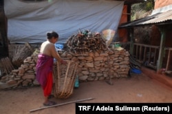 Chini Khadka arranges firewood at her small cattle farm on a remote hilltop in Bhimdhunga, Nepal, Feb. 9, 2018.