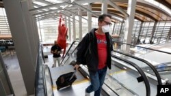 Southwest Airline passenger Robert Civettini wears a face mask as he goes to the boarding gate at Sacramento International Airport in Sacramento, Calif., Monday, May 11, 2020. (AP Photo/Rich Pedroncelli)