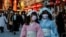 Visitors wearing protective face masks walk under decorations for the New Year at Nakamise street leading to Senso-ji temple at Asakusa district, a popular sightseeing spot, amid the coronavirus disease (COVID-19) pandemic, in Tokyo, Dec. 24, 2021. 
