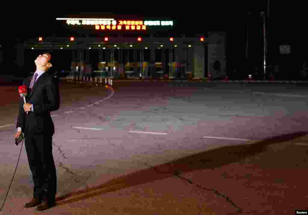 2013年4月29日，一名电视记者站在空空荡荡的韩国坡州海关移民与建议办事处的大门前准备做报道。