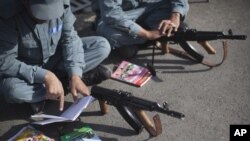 Afghan National Police recruits study their notes on how to use a Kalashnikov rifle during a training session at the police academy in Kabul, Afghanistan, October 9, 2012.