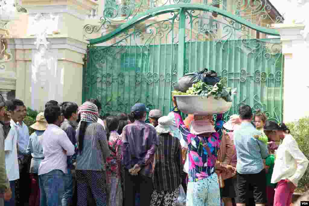 ប្រជាពលរដ្ឋកម្ពុជាកំពុងរង់ចាំនៅខាងមុខក្លោងទ្វារគេហដ្ឋានរបស់ លោកឧកញ៉ាសុខ គង់កាលពីព្រឹកថ្ងៃទី២៩ ខែមករា ឆ្នាំ២០១៩ដើម្បីទទួលអាំងប៉ាវមុននឹងពិធីបុណ្យចូលឆ្នាំចិន វៀតណាមចូលមកដល់ ក្នុងរាជធានីភ្នំពេញ ប្រទេសកម្ពុជា។(ទុំ ម្លិះ/VOA)