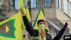 FILE - Syrian Kurds flash the V for victory sign as they celebrate the fall of capital Damascus to anti-government fighters, in the city of Qamishli on December 8, 2024.