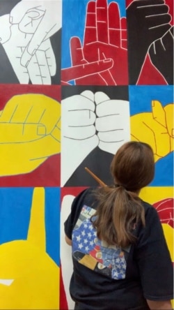 Deaf artist Nancy Rourke's painting "Eighteen Signs" hangs on display at the Deaf Action Center in Shreveport, Louisiana. (Courtesy photo)