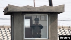 지난해 4월 북한 접경도시 신의주의 국경 초소에서 북한 병사가 망원경으로 중국 쪽을 바라보고 있다. 압록강 너머 중국 단둥에서 촬영한 사진이다.