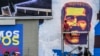 Un hombre pinta un mural del rostro del presidente Nicolás Maduro en una autopista en Caracas, el 5 de junio de 2024. 