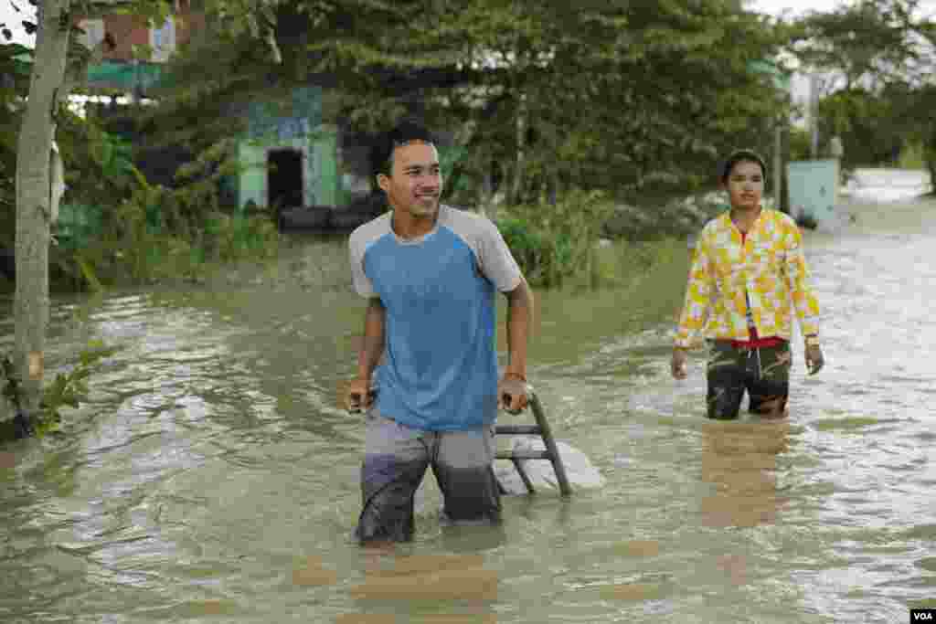 ពលរដ្ឋលីបាវខ្សាច់ដើម្បីទប់ទឹកជន់លិចនៅសង្កាត់ស្ពានថ្ម ខណ្ឌដង្កោរ ភ្នំពេញ ថ្ងៃទី១៤ ខែតុលា ឆ្នាំ២០២០។ (ទុំ ម្លិះ/វីអូអេ)