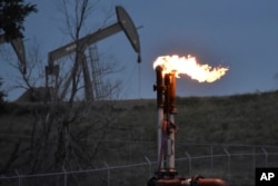 Suar yang membakar metana dari produksi minyak, 26 Agustus 2021. (Foto: AP)