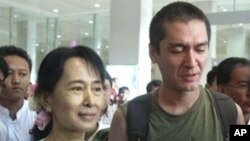 Burma's pro-democracy leader Aung San Suu Kyi holds the hand of her younger son Kim Aris after his arrival at Rangoon airport, 23 Nov 2010