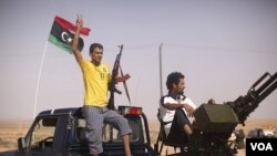 Pemberontak Libya mengacungkan tanda kemenengan, antara kawasan Tarhouna dan Bani Walid (4/9). Bani Walid adalah benteng pasukan pendukung Gaddafi.