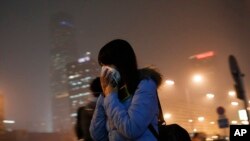 ស្រ្តី​ម្នាក់​ពាក់​ម៉ាស​ខ្ទប់​មុខ​ ខណៈ​ដើរ​សំដៅ​ទៅ​កាន់​ស្ថានីយ​រថភ្លើង​ក្រោម​ដី នៅ​ពេល​ដែល​ខ្យល់​អាកាស​នៅ​ទីក្រុង​ប៉េកាំង​មាន​ការបំពុល​យ៉ាង​ខ្លាំង​ ថ្ងៃ​ទី​៨ ខែ​ធ្នូ​ ឆ្នាំ​២០១៥។​