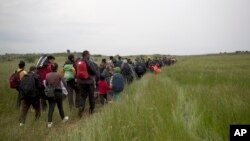 Para migran dan pengungsi di Idomeni berjalan melewati area persawahan dalam upaya menyeberangi perbatasan Yunani-Macedonia dekat desa Evzoni, 12 Mei 2016. (Foto: dok).