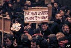 A man holds a banner during a protest in Bucharest, Romania, Nov. 26, 2017.
