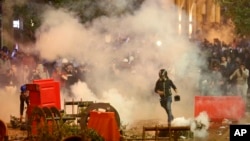FILE - Anti-government protesters clash with the riot police, during a protest near the parliament square, in downtown Beirut, Lebanon, Dec. 15, 2019.