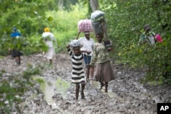 Villagers carry food for people taking care of their livestock in Tsholostho, about 200 kilometers north of Bulawayo, March 4, 2017.