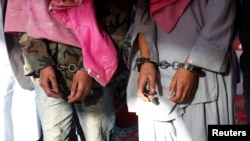 Two men in handcuffs, whom the police said belong to the Tehreek-e-Taliban Pakistan [TTP] group, are shown during a news conference at the Crime Investigation Department after their arrest, in Karachi, January 2013.
