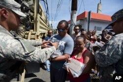 National Guardsmen arrive at Barrio Obrero in Santurce to distribute water and food among those affected by the passage of Hurricane Maria, in San Juan, Puerto Rico, Sept. 24, 2017.