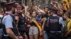 Catalan regional Mossos d'Esquadra police officers stand between protesters and the national police headquarters during a one-day strike in Barcelona, Oct. 3, 2017. 