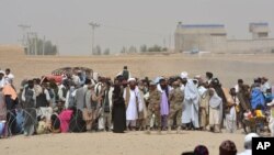 People en route to Afghanistan wait at the Pakistani border post in Chaman, in southwest Pakistan, Aug. 31, 2016. 