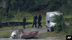 Armed police officers are seen on the island of Utoya, Norway, July 23, 2011