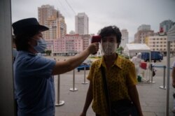 지난 8월 북한 평양 기차역 입구에서 신종 코로나바이러스 방역을 위해 승객의 체온을 재고 있다.