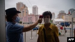 지난 13일 북한 평양 기차역 입구에서 신종 코로나바이러스 방역을 위해 승객의 체온을 재고 있다.