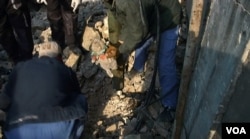 An Iraqi rescue worker holding a stuffed animal belonging to an unidentified child found dead under the rubble of the Old City in Mosul. January 2018. (K Omar/VOA)