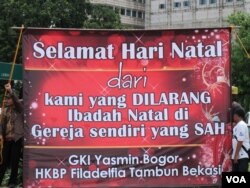 Sebuah spanduk berukuran raksasa terlihat dipasang di depan Istana negara Jakarta, sebagai bagian dari dekorasi sederhana yang menghiasi perayaan Natal yang digelar jemaat gereja GKI Yasmin Bogor dan HKBP Filadelphia Tambun, Bekasi (25/12).