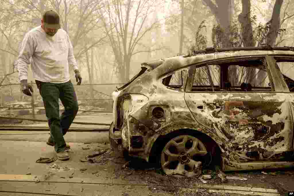 Eric England searches through a friend&#39;s vehicle on Pearson Rd. after the wildfire burned through Paradise, Calif., Nov. 10, 2018. Not much is left in Paradise after a ferocious wildfire roared through the Northern California town as residents fled and entire neighborhoods are leveled.