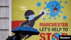 A man walks past a poster amid the outbreak of the coronavirus disease, in Manchester, Britain, Oct. 21, 2020. (Reuters)