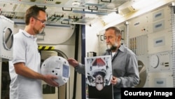 CIMON project manager Till Eisenberg (left) and Josef Sommer, CIMON GNC Team Leader at Airbus, are testing CIMON with images of Astronaut Alexander Gerst. (Airbus)