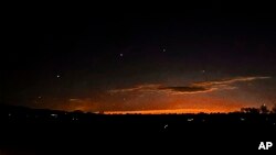 Cette photo fournie par Trisha Bushey montre des points de lumière dans le ciel en soirée près de Lebanon Township, dans le New Jersey, le jeudi 5 décembre 2024. (Trisha Bushey via AP)