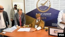 리비아 전 독재자 무아마르 가다피의 아들 사이프 알이스람 가다피(가운데 앉은 사람)가 14일 다음달 열리는 대통령 선거 후보로 등록했다.