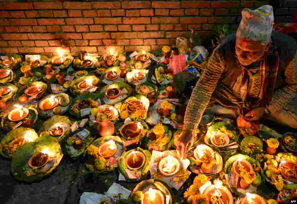 A Hindu devotee lights oil lamp in memory of deceased family members during the Balachaturdashi festival at the Pashupatinath Temple in Kathmandu, Nepal.