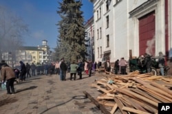 Residents wait for food at the field kitchen outside of the Donetsk Academic Regional Drama Theater on March 9, 2022, in Mariupol. The Associated Press reported the March 16, 2022, bombing of the theater stands out as the single deadliest known attack against civilians to date in the Ukraine war. (Lev Sandalov/Associated Press)