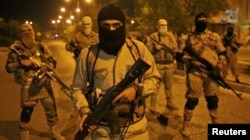 A still image taken from an Islamic State (IS) video released through the group's Amaq news agency shows an unidentified militant addressing the camera. The video is said to be shot in Mosul, Iraq, Oct. 18, 2016.