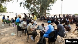 A United Nations High Commissioner for Refugees (UNHCR) staff member registers migrants inside a detention centre at Ain Zara, in Tripoli, Libya, Oct. 12, 2021. 