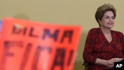 Presiden Brazil Dilma Rousseff di depan poster bertuliskan "Dilma Bertahanlah" dalam sebuah upacara peluncuran program pendidikan di Istana Kepresidenan Planalto di Brasilia (9/5). (AP/Eraldo Peres)