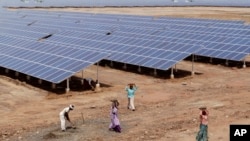 រូបថតឯកសារ៖ កម្មករ​ឥណ្ឌា​ធ្វើការ​នៅ​ក្បែរ​បន្ទះ​ថាមពល​ពន្លឺព្រះអាទិត្យ​នៅ​ឯ​ឧទ្យាន​ផលិត​ថាមពលពី​ពន្លឺព្រះអាទិត្យ​ក្នុង​ស្រុក Patan ស្ថិតនៅ​ចម្ងាយ​ប្រហែល​២៥០គីឡូម៉ែត្រពីទីក្រុង​ Ahmadabad នៃប្រទេស​ឥណ្ឌា។