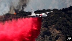 A firefighting aircraft makes a low-altitude pass to drop fire retardant to battle a wildfire near Bradbury, Calif., June 22, 2016