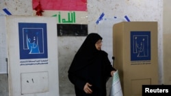 An Iraqi woman visits a polling station to cast her vote, during Iraq's provincial council elections, in Baghdad, Iraq, Dec. 18, 2023. 