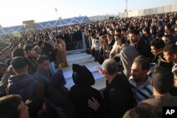 FILE - People attend the funeral of policemen killed in a truck bomb blast at a police training school in the western Libyan town of Zliten, Jan. 7, 2016.