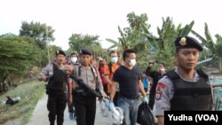 Polisi bersenjata sita barang bukti dari hasil penggeledahan di Pasar Kliwon, Solo, Rabu, 12 Agustus 2015 (Foto: VOA/Yudha)