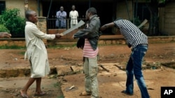 FILE - Muslim men organized in militias with machetes rough up a Christian man while checking him for weapons in the Miskine neighbourhood of Bangui, Central African Republic, Dec. 13, 2013.