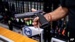 Foto ilustrasi menunjukkan seorang penjual senjata api memperlihatkan sebuah pistol yang dapat dibeli di toko SP firearms di Hempstead, New York, pada 23 Juni 2022. (Foto: AP/Brittainy Newman)