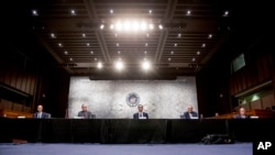 Lawmakers and officials keep space between themselves during a meeting to discuss the coronavirus relief bill on Capitol Hill in Washington. 