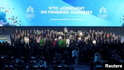 2024年2月26日，在阿拉伯联合酋长国阿布扎比举行的第13届世界贸易组织部长级会议上，代表们合影留念。(路透社）